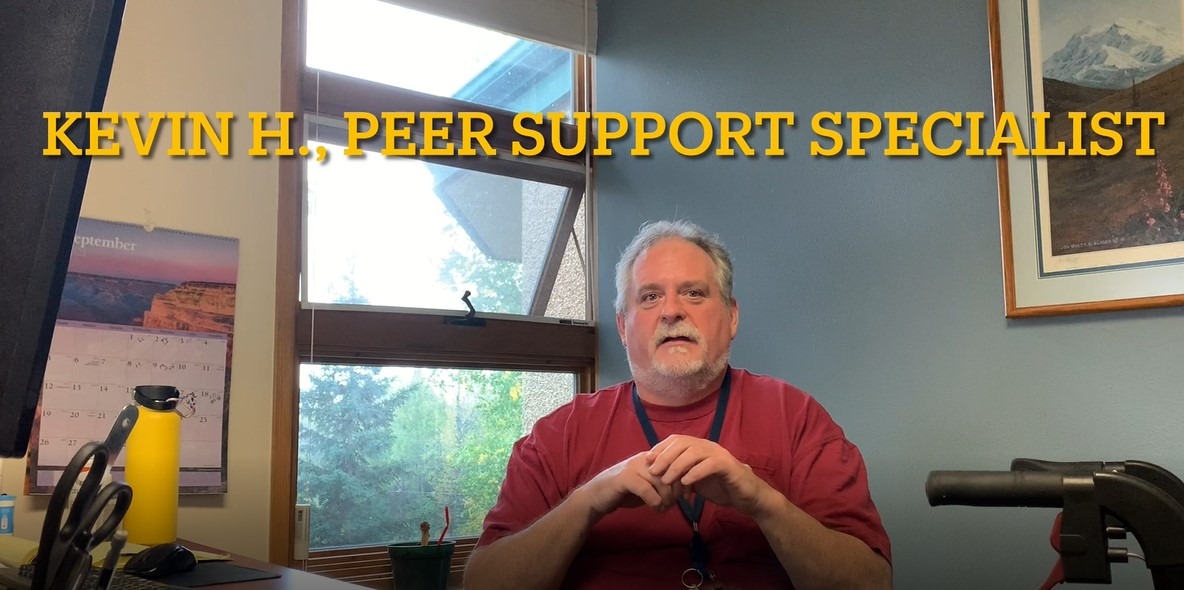 man in red shirt at desk