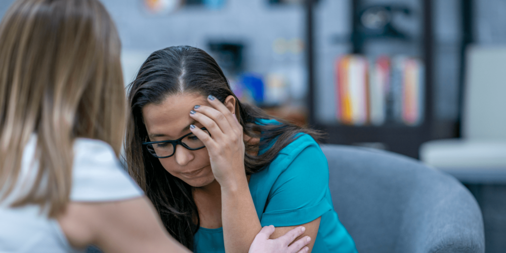woman being comforted by another woman