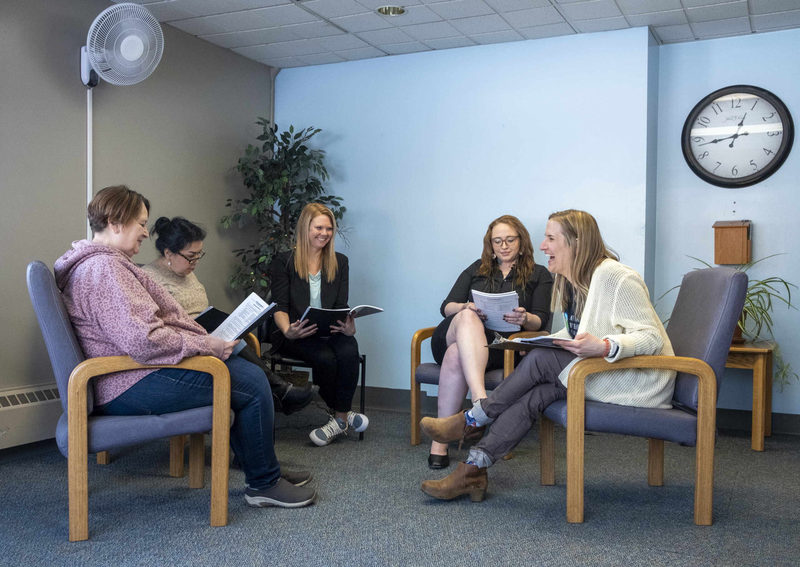a group of women sitting in a circle on chairs